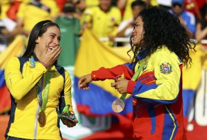 2016 Rio Olympics - Cycling BMX - Victory Ceremony - Women's BMX Victory Ceremony - Olympic BMX Centre - Rio de Janeiro, Brazil - 19/08/2016. Gold medalist Mariana Pajon (COL) of Colombia reacts on podium with bronze medalist Stefany Hernandez (VEN) of Venezuela.  REUTERS/Paul Hanna  FOR EDITORIAL USE ONLY. NOT FOR SALE FOR MARKETING OR ADVERTISING CAMPAIGNS.